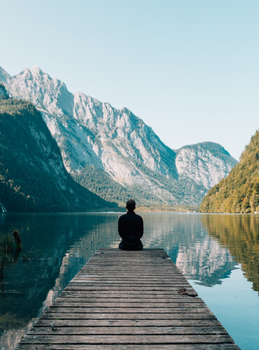 a man sitting near mountains